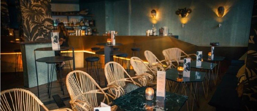 Voodoo Reyes after the build: teal walls, rattan chairs and a copper bar